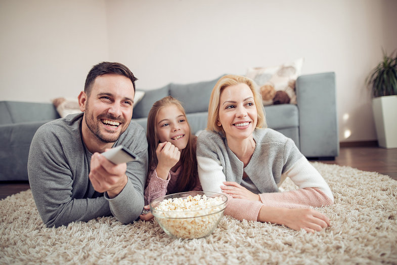 Eine Familie, die Popcorn teilt und Fernsehen schaut