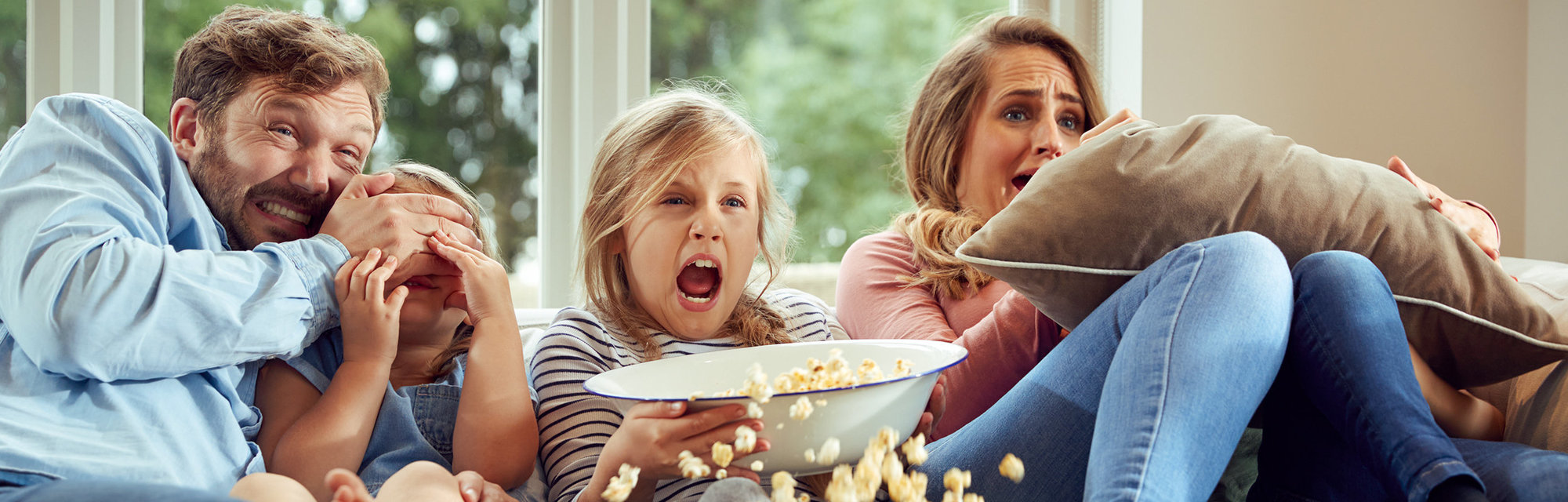Eine Familie, die auf dem Sofa sitzt und Fernsehen schaut
